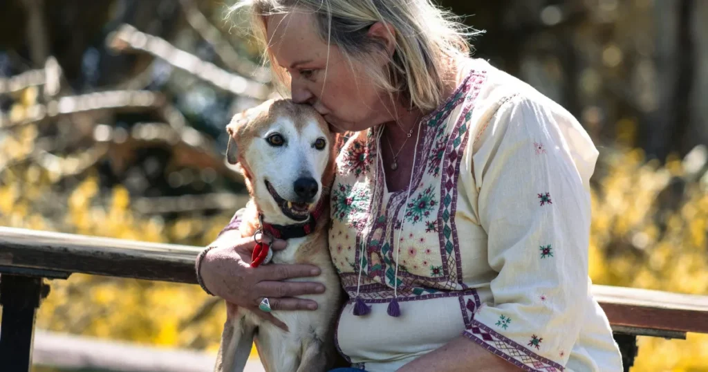 Older woman hugging her dog outdoors