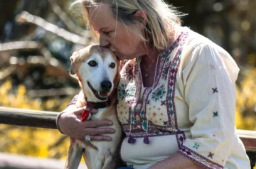 Older woman hugging her dog outdoors