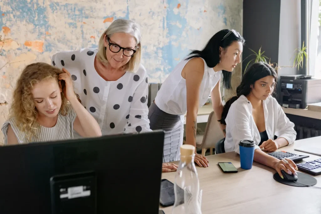 Older woman supervising a team at computers