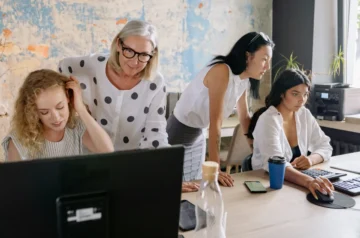 Older woman supervising a team at computers