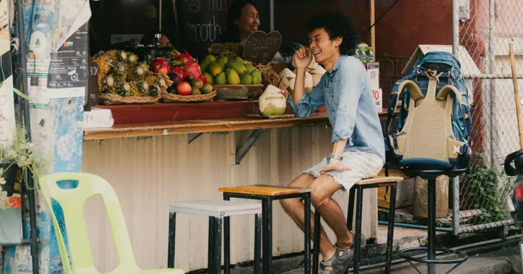 Person buying fresh coconut at a fruit stand in Mexico