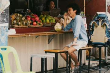 Person buying fresh coconut at a fruit stand in Mexico