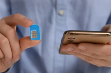 Person inserting a SIM card into a mobile phone