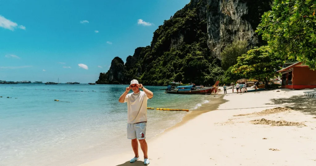 Person on a Thai beach with limestone cliffs in the background
