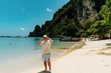 Person on a Thai beach with limestone cliffs in the background