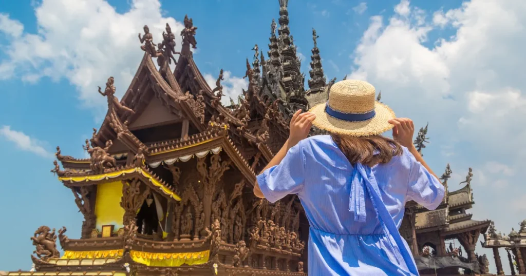 Tourist photographing a wooden temple in Thailand