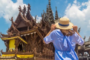 Tourist photographing a wooden temple in Thailand