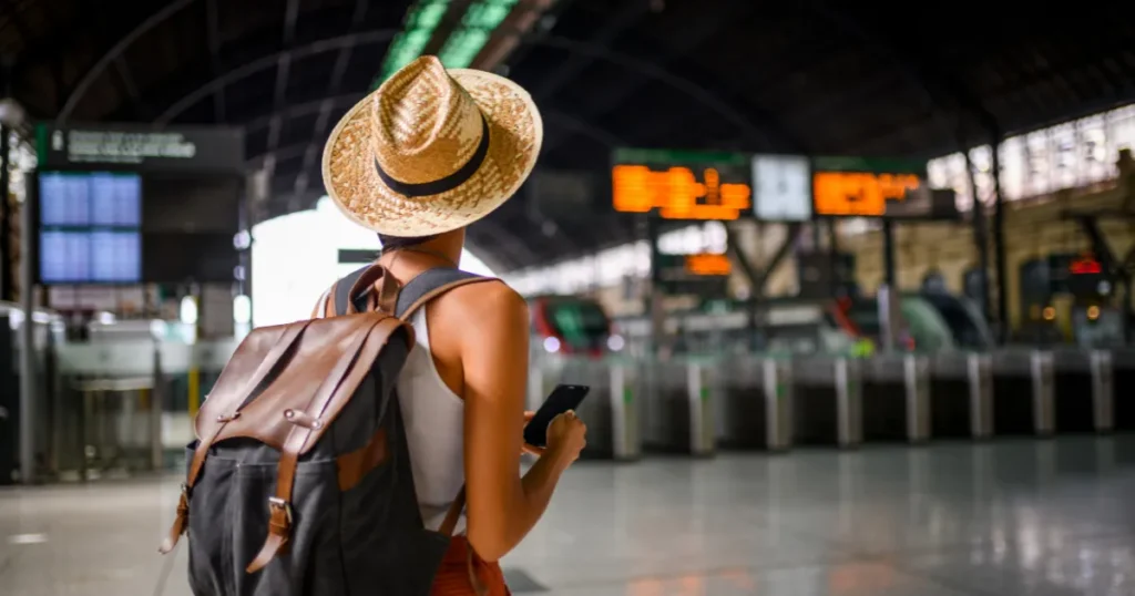Traveller at a train station checking their phone