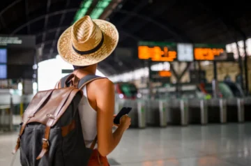 Traveller at a train station checking their phone