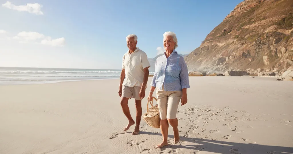 Two older men walking together on the beach