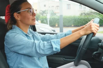 Woman wearing glasses while driving a car