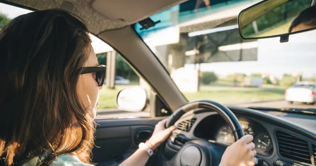 Rear view of a woman driving a car