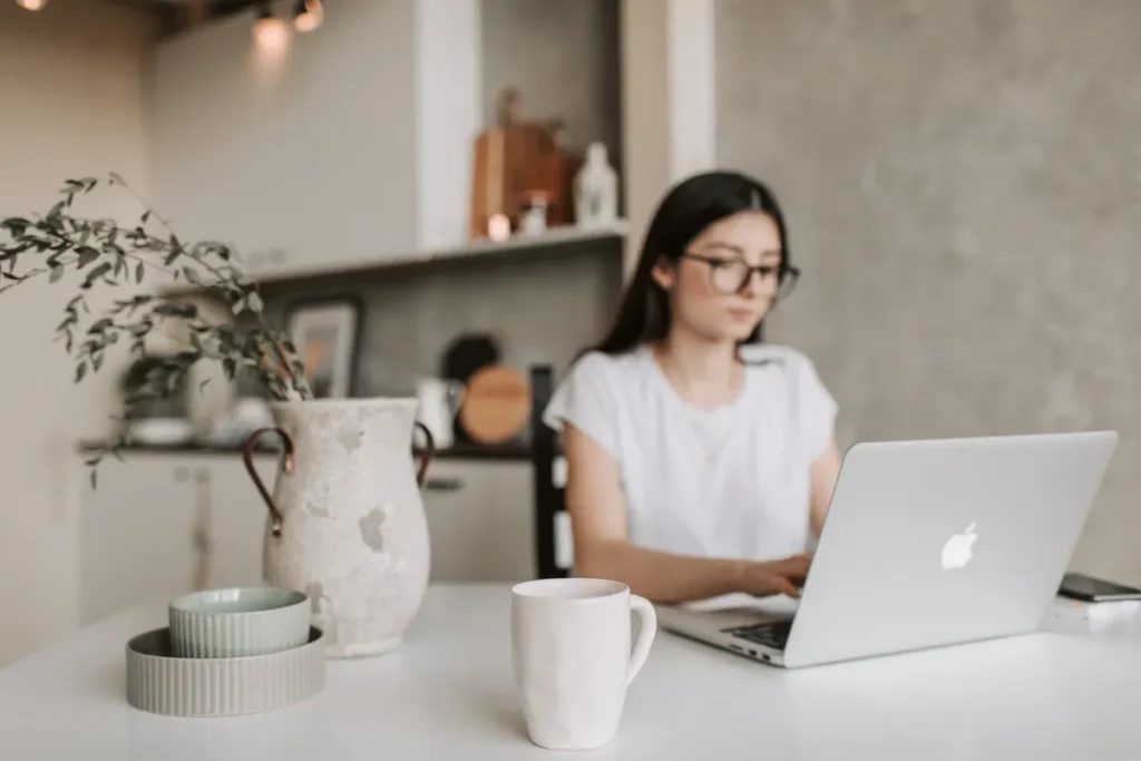 Woman working on laptop in home kitchen